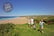 A family taking a walk along a cliff top over looking a beach