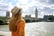 Tourism in London. Back view of traveler girl enjoying sight of Westminster bridge and palace on River Thames 