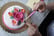 Baker decorating a cake with beautiful edible flowers