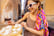 Woman eating pizza and drinking wine at restaurant on a street in Rome.