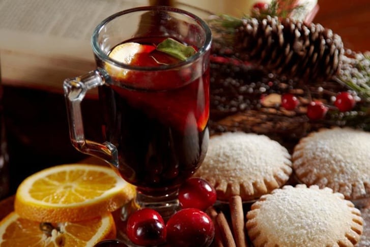 A glass of mulled wine amongst mince pies