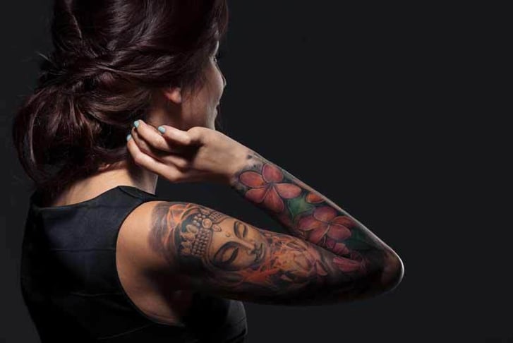 A woman with a tattoo down her arm 