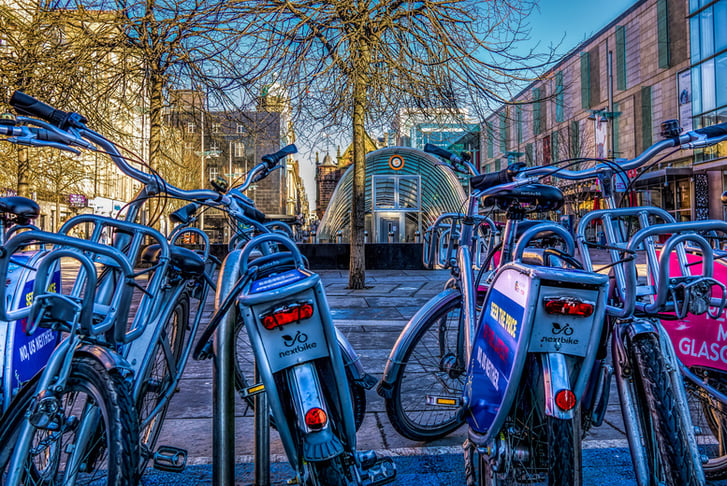Nextbikes outside of a Glasgow train station