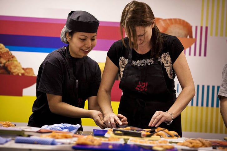 A chef helping a student at a Yo Sushi cooking class