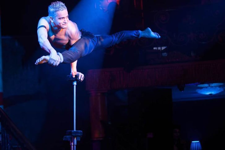 An acrobat performing at the Cafe de Paris, balancing on a unicycle