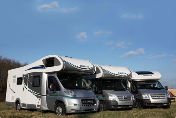 Three motor-homes parked in a line