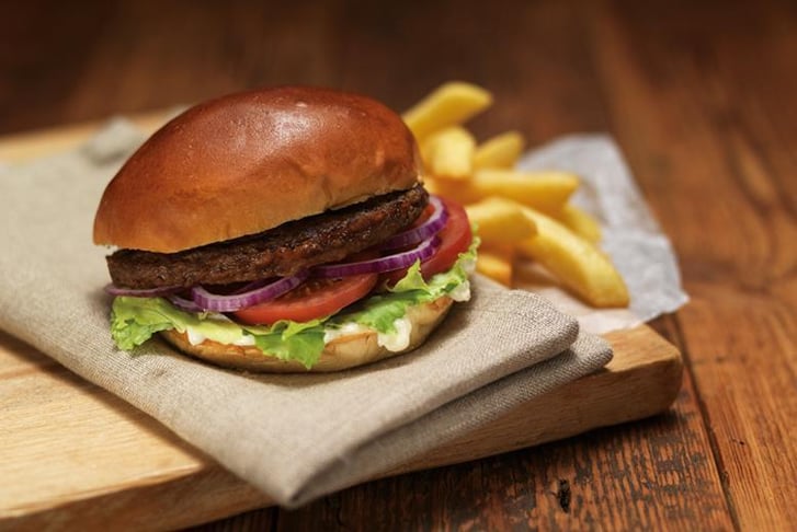 A Burger and fries on a wooden board