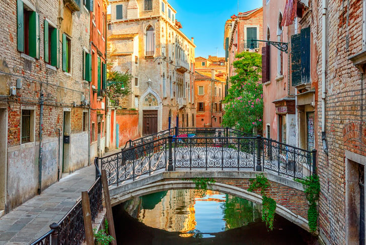 Narrow canal with bridge in Venice, Italy.