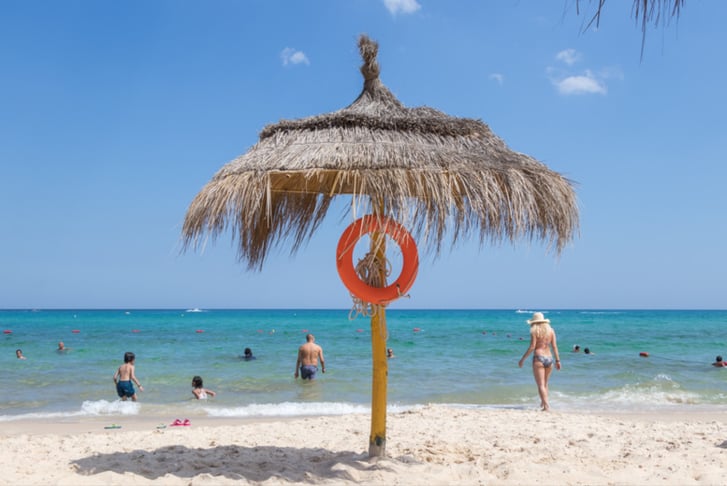 Beach umbrella with life-saving equipment and the Mediterranean Sea