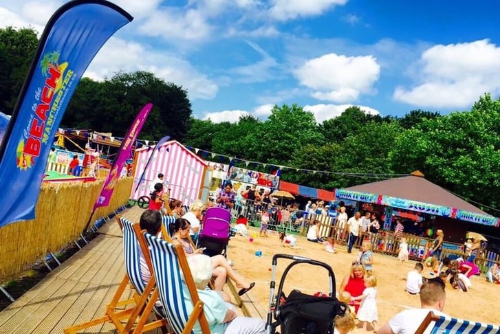 People at an artificial beach at a fun fair in Manchester