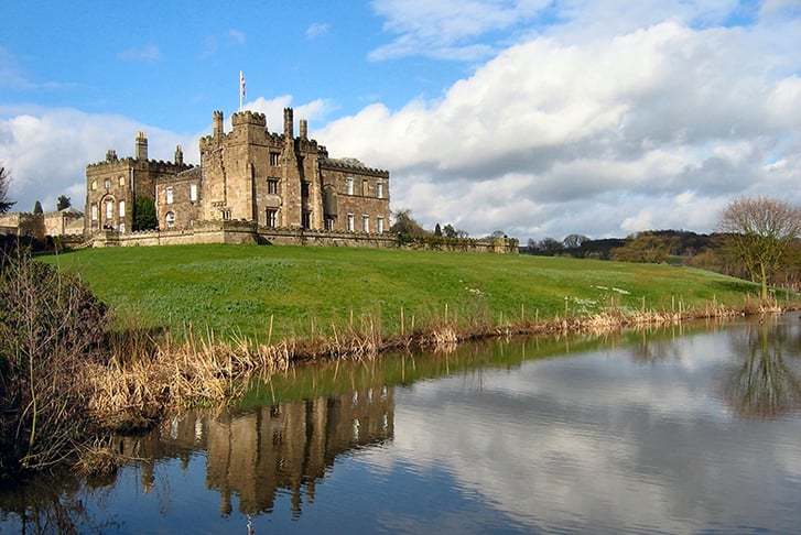 The view of Ripley Castle from a riverbank