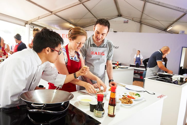 A couple taking a cooking class at the Taste of London food festival