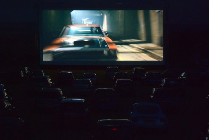 Cars lined up at a drive in cinema at night