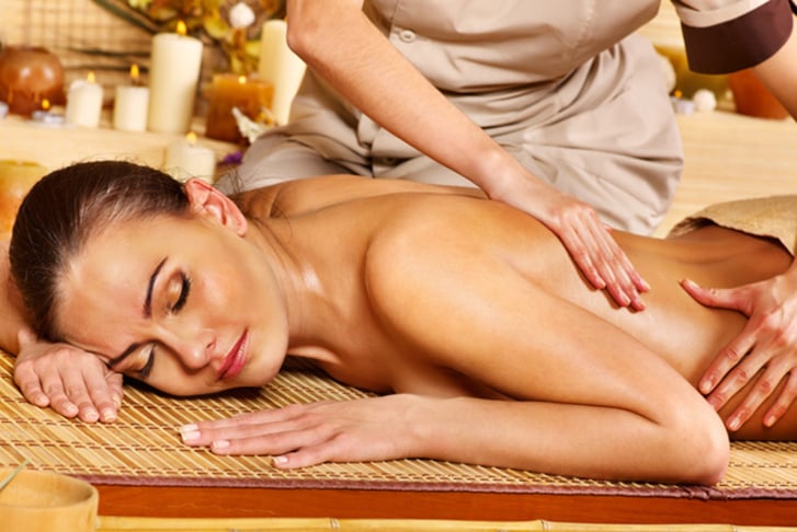 A woman at a massage parlour receiving a back massage 