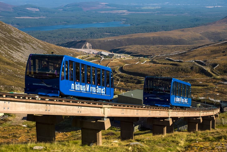 CairnGorm Mountain Funicular Trains on the track going through the countryside
