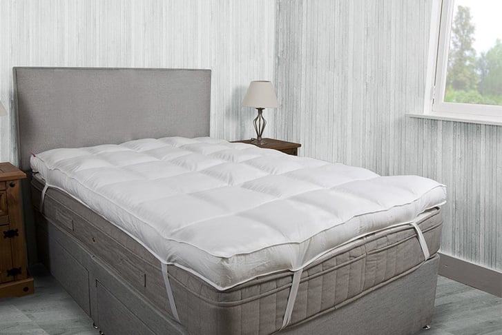 A microfibre mattress topper on a mattress in a bedroom