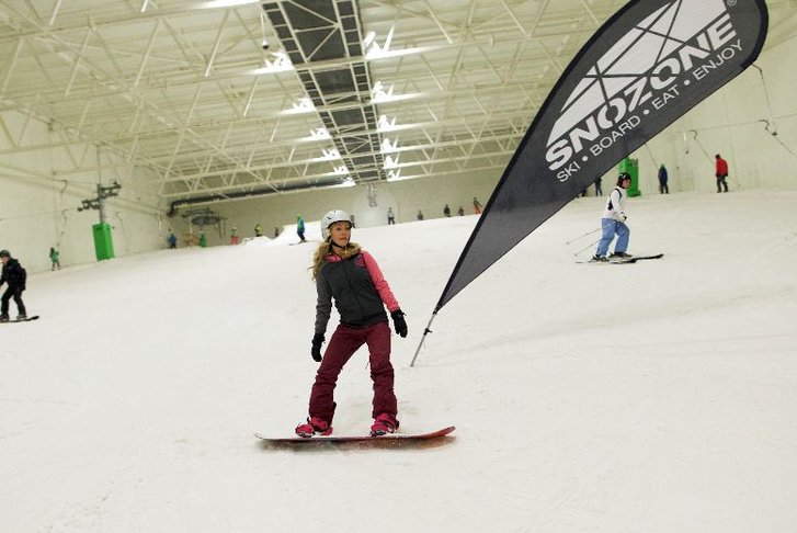 A woman on a snowboard at Snozone 