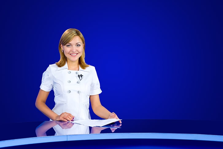 TV presenter sitting at desk