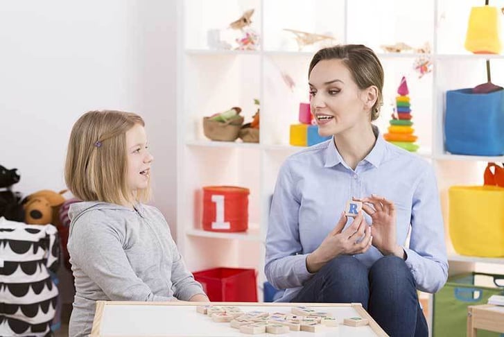 Speech therapist working with young girl