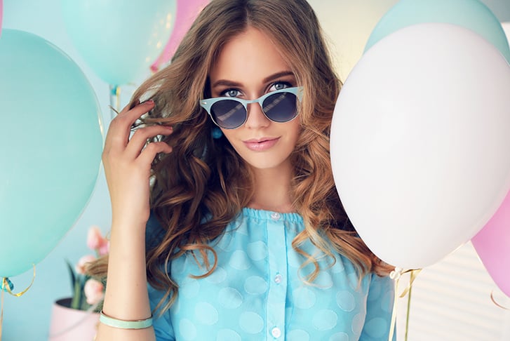 Woman in sunglasses surrounded by balloons