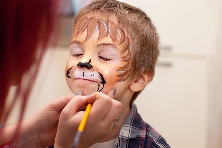 A child getting a lion painted on their face