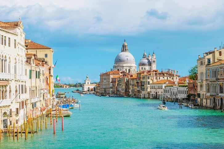 View of Venice Grand Canal with Saint Mary of Health dome on sunny day.