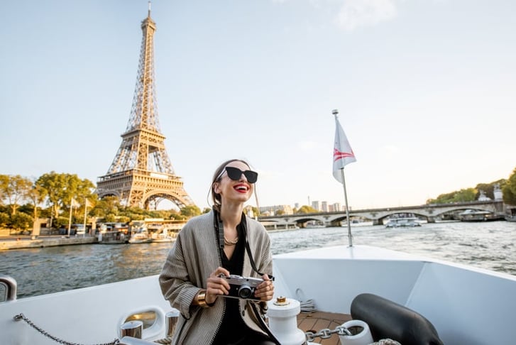 Young woman enjoying beautiful landscape view on the riverside with Eiffel tower from the boat