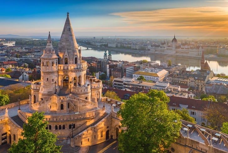 Budapest, Hungary - Beautiful golden summer sunrise with the tower of Fisherman's Bastion and green trees.